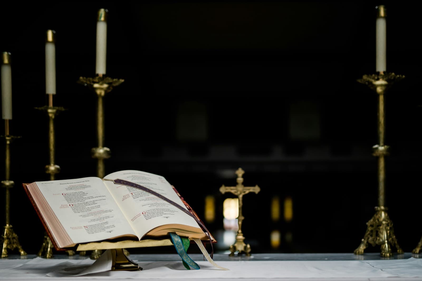 Misal abierto sobre el altar, entre cirios y la cruz.